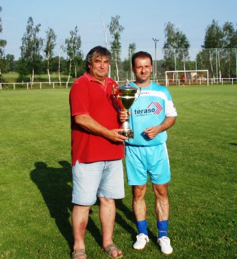 Mameriál Františka Pavlovského a Josefa Smitky - 4.7.2006
Pamlu vítězství si odvezl favorit , nováček divize FK Horažďovice. Na snímku apitán Horažďovic Daniel Boček a ředitel turnaje Vladimír Smitka s putovním pohárem

