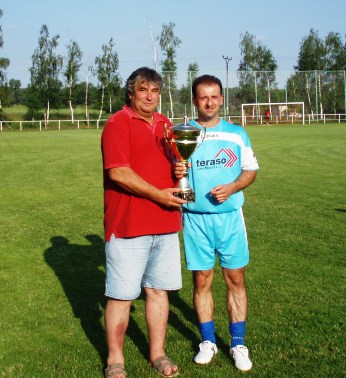 Mameriál Františka Pavlovského a Josefa Smitky - 4.7.2006
Pamlu vítězství si odvezl favorit , nováček divize FK Horažďovice. Na snímku apitán Horažďovic Daniel Boček a ředitel turnaje Vladimír Smitka s putovním pohárem
